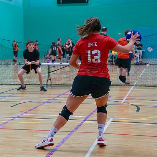 Girl viewed from behind throwing ball at Surrey Dodgeball